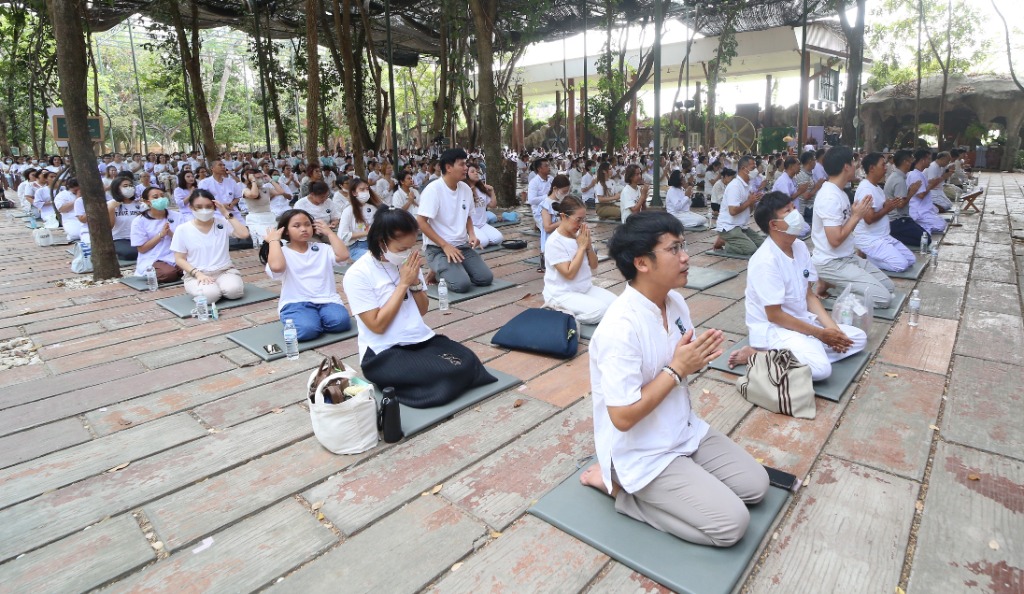 สุภาพสตรีพนมมือตั้งมั่นเจริญวิปัสสนากรรมฐานร่วมกัน