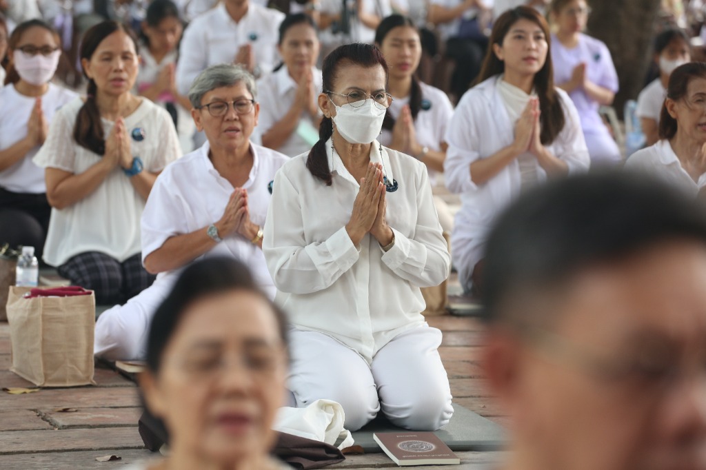 คณะผู้ปฏิบัติธรรมสวมหน้ากากอนามัยพนมมือฟังธรรมเทศนาจากพระอาจารย์