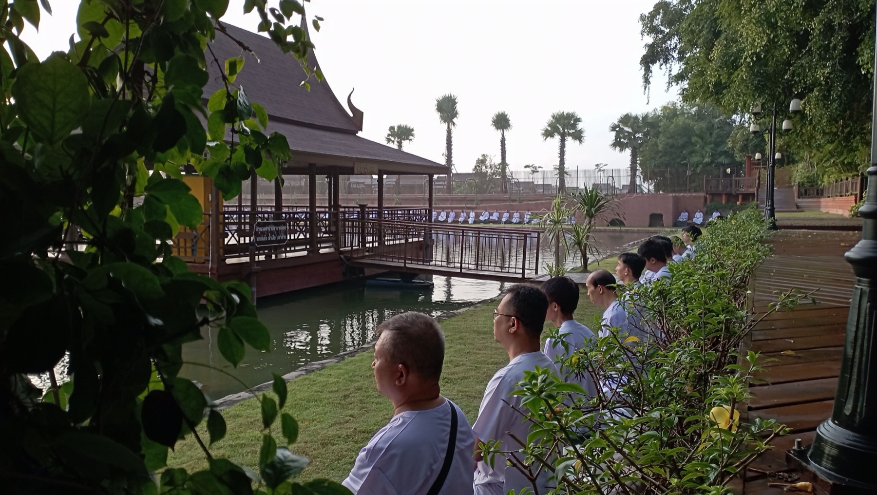 ผู้ปฏิบัติธรรมนั่งภาวนารอบสระน้ำ