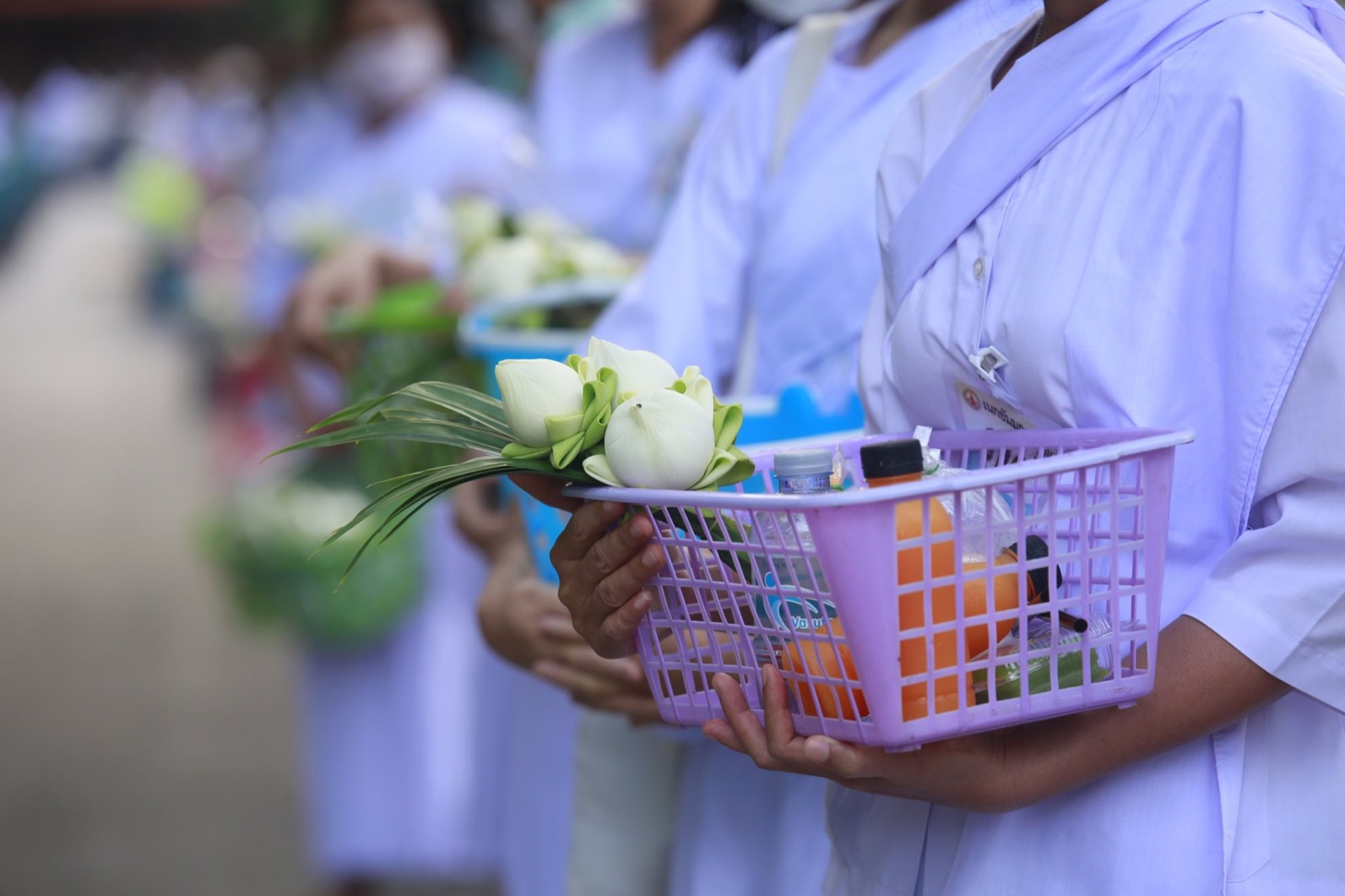 ผู้ปฏิบัติธรรมถือดอกบัวและของใช้ส่วนตัว