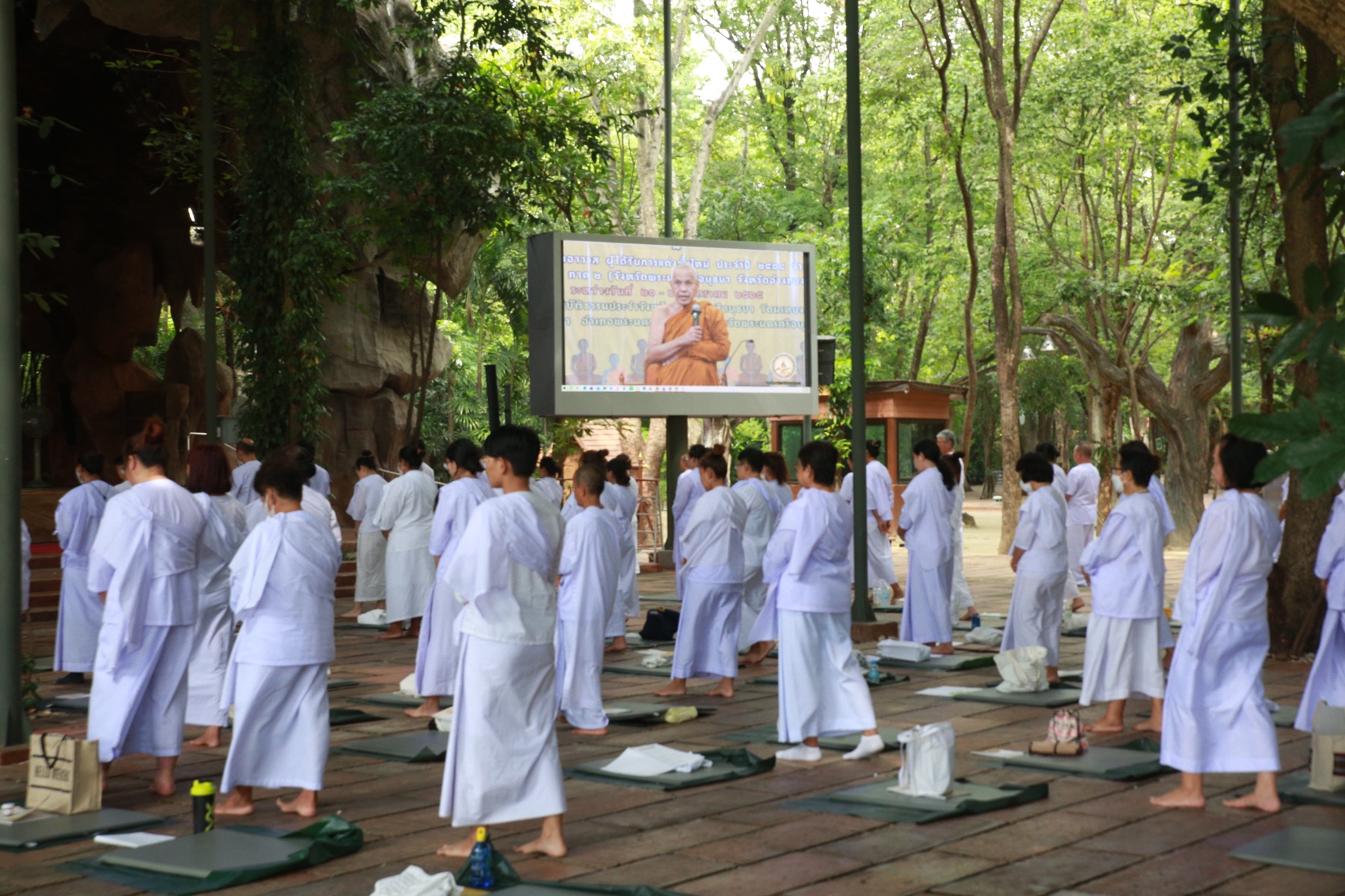 ผู้ปฏิบัติธรรมเดินจงกรมต่อหน้าจอธรรมบรรยาย