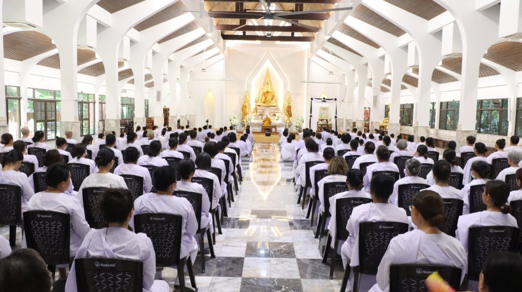 ผู้ปฏิบัติธรรมเดินจงกรมแถวเรียงเดี่ยวสะท้อนเงาผืนน้ำ