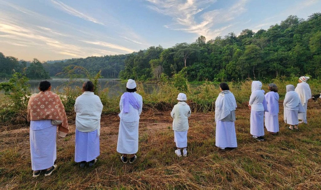 ผู้ปฏิบัติธรรมยืนภาวนาข้างสระน้ำที่สาขาพะเยา